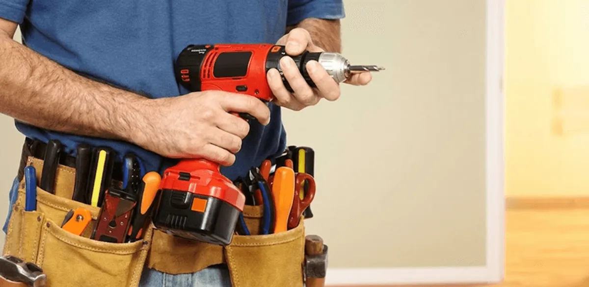 Handyman holding a power drill for home repairs and installations in Birmingham, AL